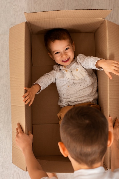 Bovenaanzicht broers spelen met doos