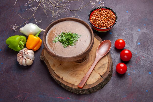 Bovenaanzicht bruine bonensoep heerlijke gekookte soep met groenten op donkere ondergrond groentesoep maaltijd voedselolie