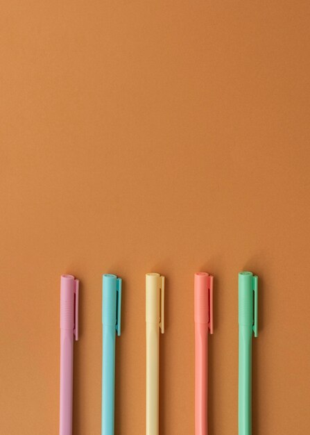Bovenaanzicht bureauopstelling met kleurrijke pennen