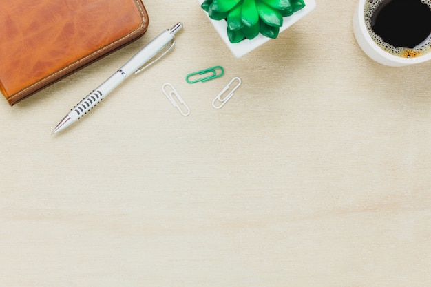 Bovenaanzicht business office desk.the notebook, potlood, zwarte koffie, boom, paperclips op houten tafel achtergrond.