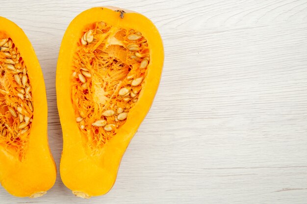 Bovenaanzicht butternut squash in tweeën gesneden op witte achtergrond