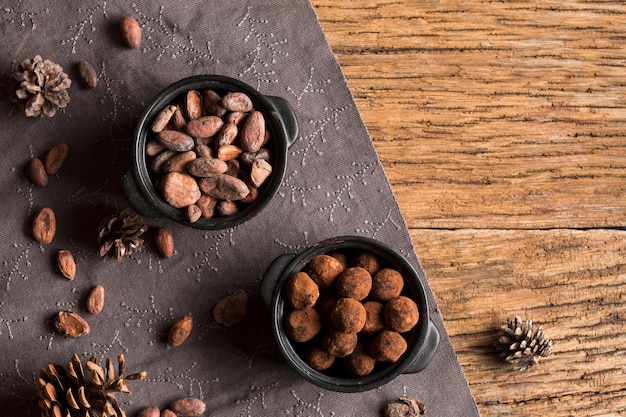 Bovenaanzicht cacaobonen en chocolade truffels in kommen