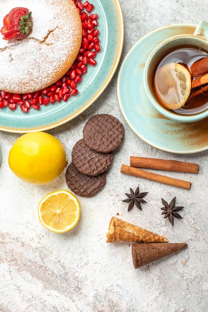 Bovenaanzicht cake met aardbeien kaneel een kopje thee met citroen de cake cookies