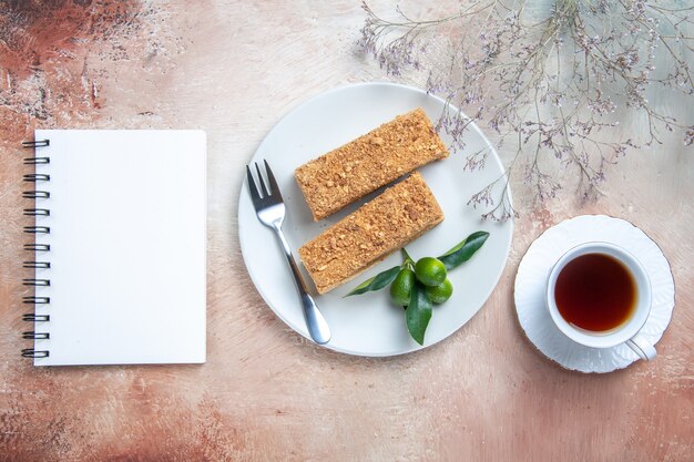 Bovenaanzicht cake plakjes honing cake met kopje thee op licht