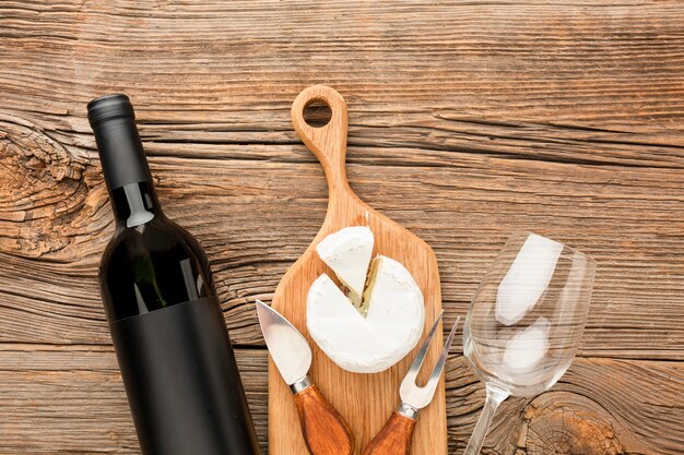 Bovenaanzicht camembert op houten snijplank wijn en glas