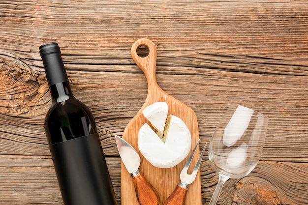 Bovenaanzicht camembert op houten snijplank wijn en glas