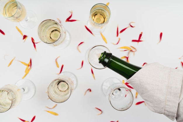 Gratis foto bovenaanzicht champagne gieten in glas