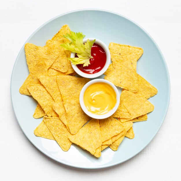 Bovenaanzicht chips en saus op plaat