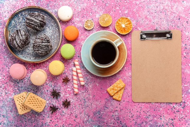 Bovenaanzicht chocoladetaart met Franse macarons op lichtroze