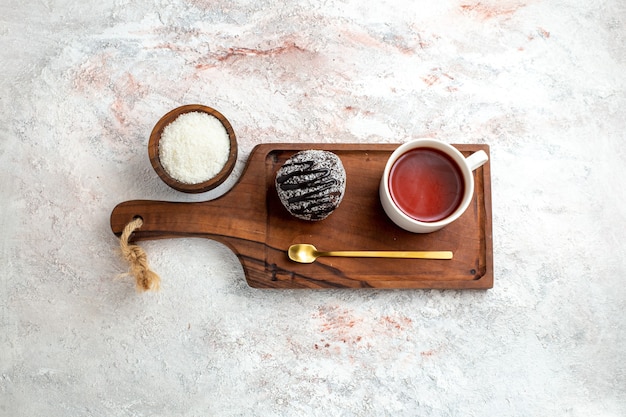 Bovenaanzicht chocoladetaart met kopje thee op de witte achtergrond chocoladetaart koekje suiker zoet koekje