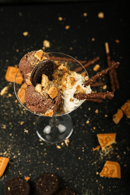 Bovenaanzicht chocolate chip cookies met slagroom en chocolade sticks in glas op zwarte tafel