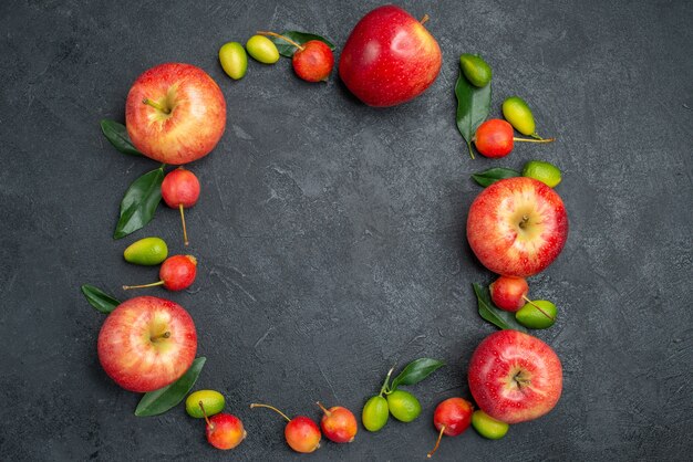 Bovenaanzicht close-up fruit rode appels kersen citrusvruchten zijn neergelegd in een cirkel