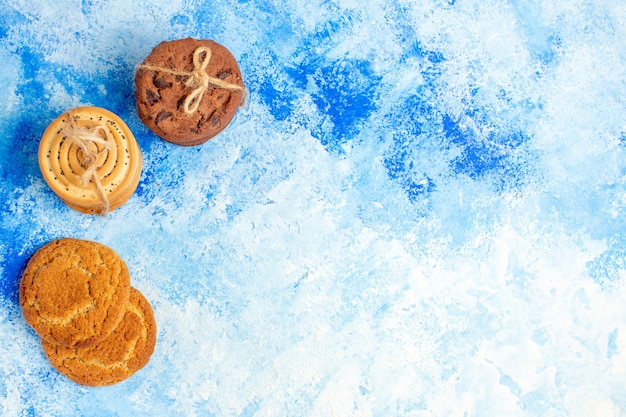 Bovenaanzicht cookies vastgebonden met touw op blauwe tafel