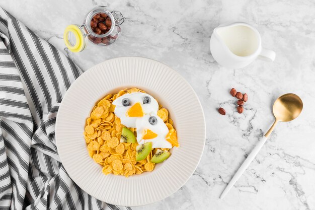 Bovenaanzicht cornflakes met fruit en yougurt