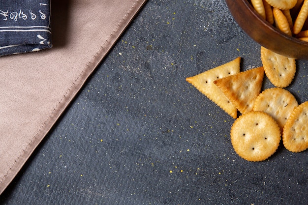 Gratis foto bovenaanzicht crackers en chips op de donkere achtergrond zout cracker knapperige snack