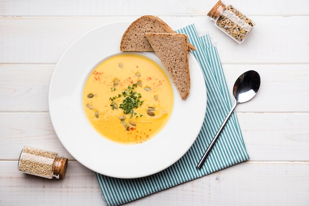 Bovenaanzicht creme soep met sneetjes brood en zaden