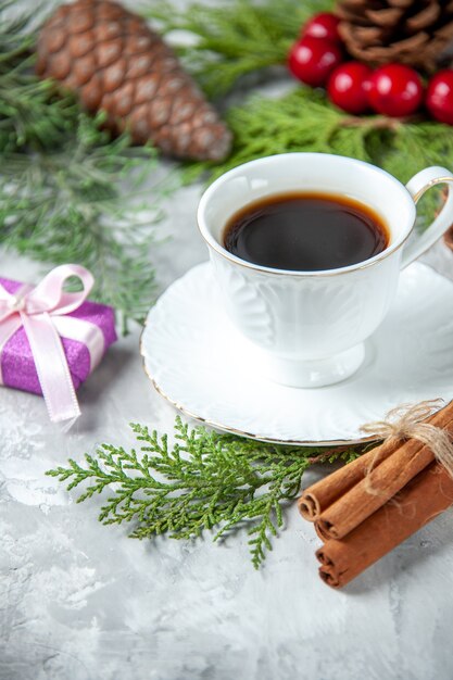 Bovenaanzicht dennenboom takken klein geschenk kopje thee op grijze ondergrond