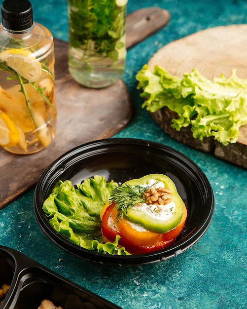 Bovenaanzicht dieet voedsel multi-gekleurde paprika op sla met walnoot en detox water