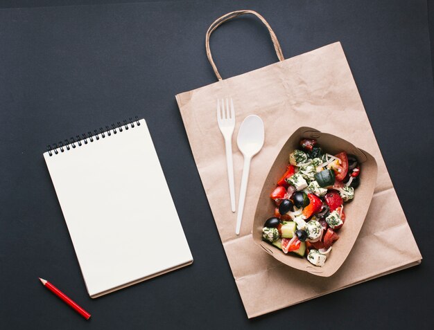 Bovenaanzicht doos met salade op papieren zak