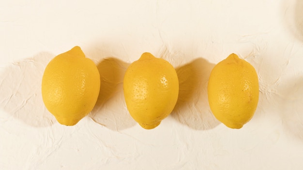 Bovenaanzicht drie verse citroenen uitgelijnd op tafel