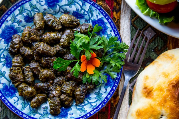 Bovenaanzicht een traditionele azerbeidzjaans gerecht dolma vlees in druivenbladeren met peterselie en wortelenjpg