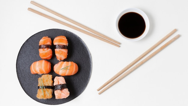 Bovenaanzicht eetstokjes naast plaat met sushi