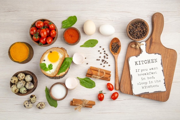 Gratis foto bovenaanzicht ei toast met tomaten en kruiderijen op witte achtergrond foto ochtend ontbijt lunch salade kleur voedsel