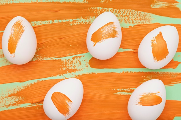 Gratis foto bovenaanzicht eieren met aquarel oranje stakingen