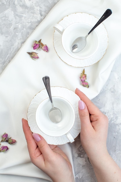 Bovenaanzicht elegante kopjes met plaat lepels en bloemen op witte oppervlakte horizontale kleur glas voedsel keuken keukentafel