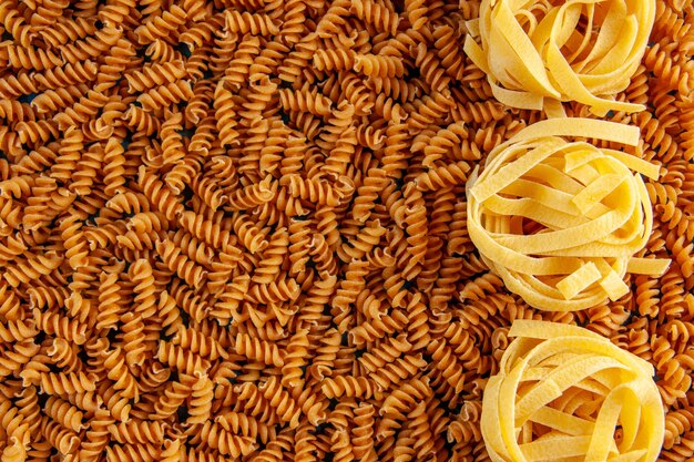 Gratis foto bovenaanzicht en hoge resolutie foto van verschillende rauwe italiaanse pasta's op een rij