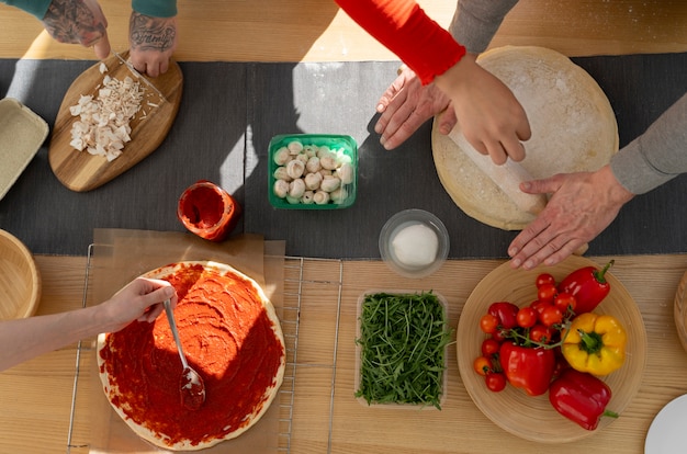 Gratis foto bovenaanzicht familie heerlijke pizza koken