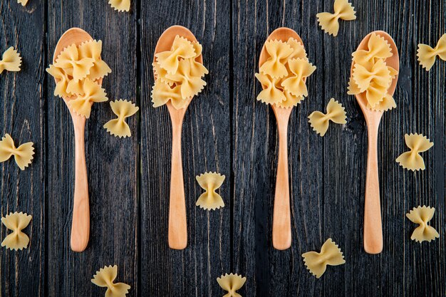 Bovenaanzicht farfalle pasta op zwarte houten achtergrond