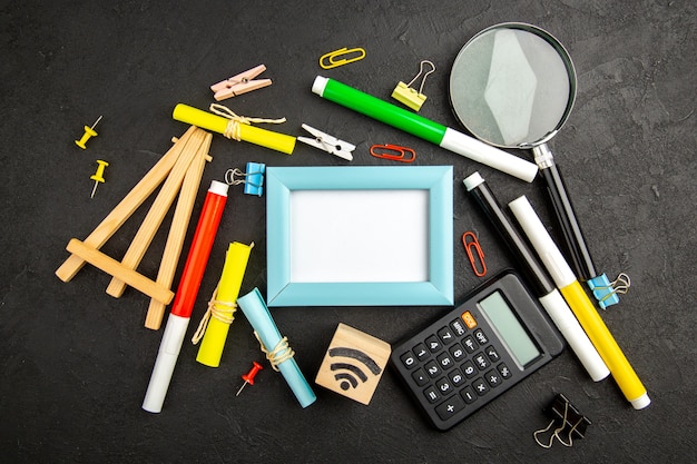 Bovenaanzicht fotolijst met kleurrijke potloden op donkere oppervlakte kunst kleur tekening college voorbeeldenboek school notitieblok