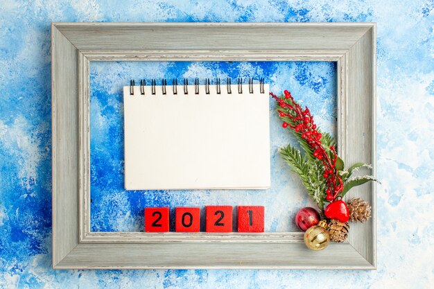 Bovenaanzicht frame xmas boomtak met speelgoed houten blokken notebook op blauwe tafel