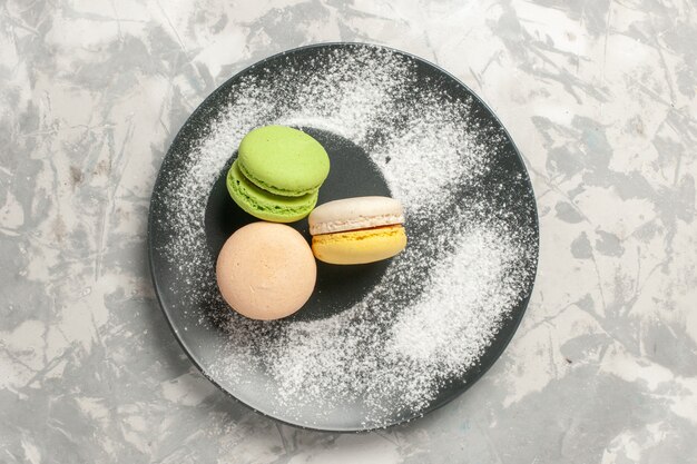 Bovenaanzicht Franse macarons kleine heerlijke taarten op wit oppervlak koekje suiker cake zoete taart thee koekje