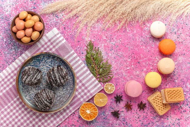 Bovenaanzicht Franse macarons met chocoladetaart op lichtroze