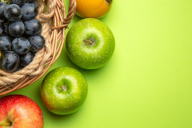 Bovenaanzicht fruitmand met zwarte druiven persimmon appels