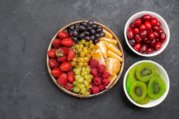 Bovenaanzicht fruitsamenstelling verschillende vers fruit op donkergrijze ruimte