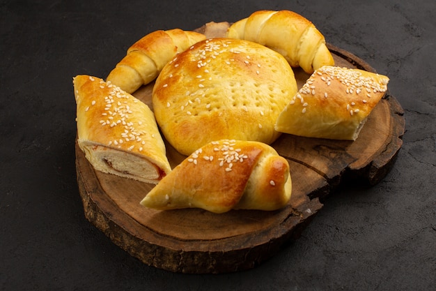 Bovenaanzicht gebak en croissants lekker op het donkere bureau