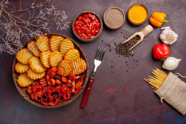 Gratis foto bovenaanzicht gebakken aardappelen met gekookte groenten en kruiden op donker bureau