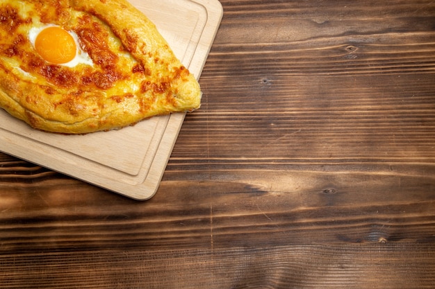 Bovenaanzicht gebakken brood met gekookt ei op houten achtergrond brood broodje voedsel eieren ontbijt deeg