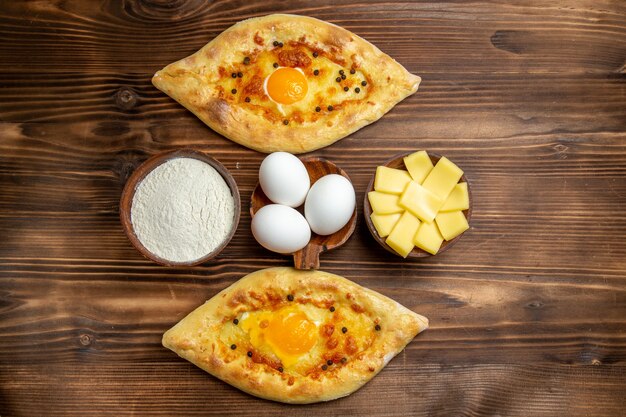 Bovenaanzicht gebakken eierbrood vers uit de oven op bruin houten bureau deeg ei brood ontbijt