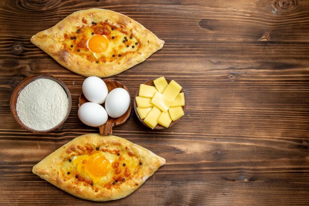 Bovenaanzicht gebakken eierbrood vers uit de oven op het bruine houten bureau deeg ei broodje ontbijt brood