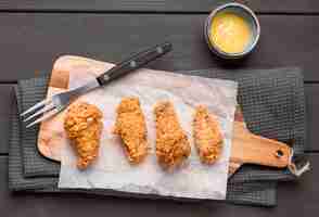 Gratis foto bovenaanzicht gebakken kippenvleugels op snijplank met saus