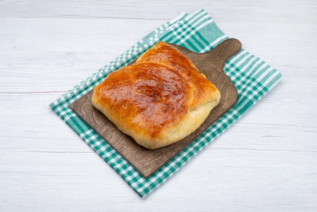 Bovenaanzicht gebakken lekker broodje op het houten bureau en witte achtergrond broodje brood foto