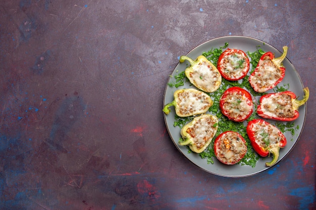 Bovenaanzicht gebakken paprika's met kaasgroenten en vlees in de plaat op de donkere achtergrond bak diner schotel eten maaltijd