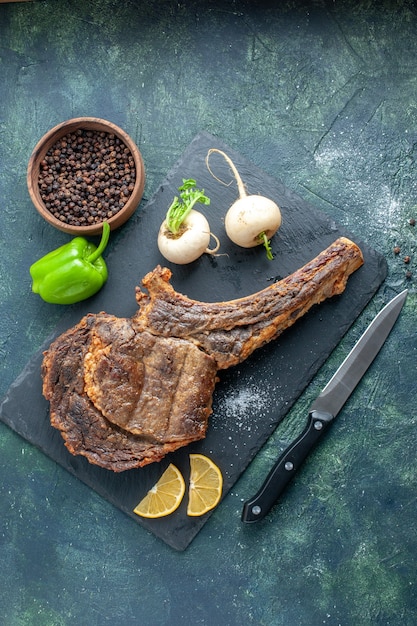 Bovenaanzicht gebakken vlees plak op donkere achtergrond vlees eten schotel bak kleur dier rib diner koken barbecue