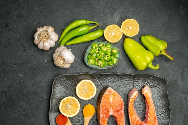 Bovenaanzicht gebakken vlees plakjes met paprika, knoflook en citroen op donkere achtergrond