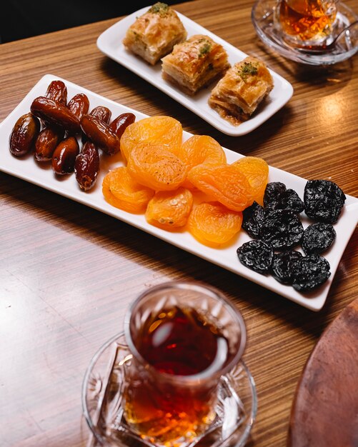 Bovenaanzicht gedroogd fruit met Turkse baklava en een glas armudu thee