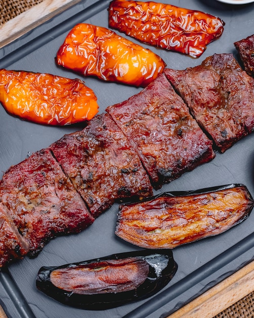 Bovenaanzicht gegrild vlees met paprika en gegrilde aubergine op een dienblad